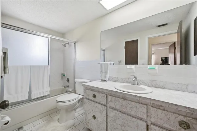 a bathroom with a toilet a sink a mirror and a shower