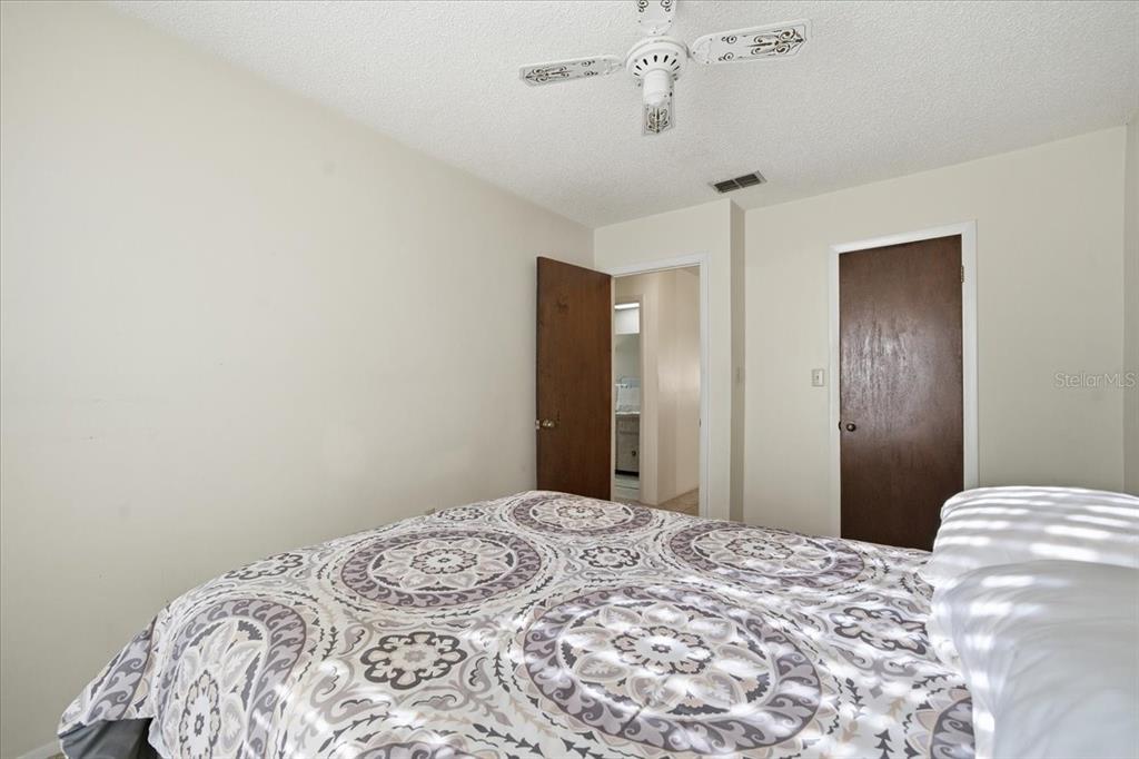 12439 Hanley Drive Spring Hill, FL 34608 - Photo 27 of 36 a bedroom with a bed and a chandelier