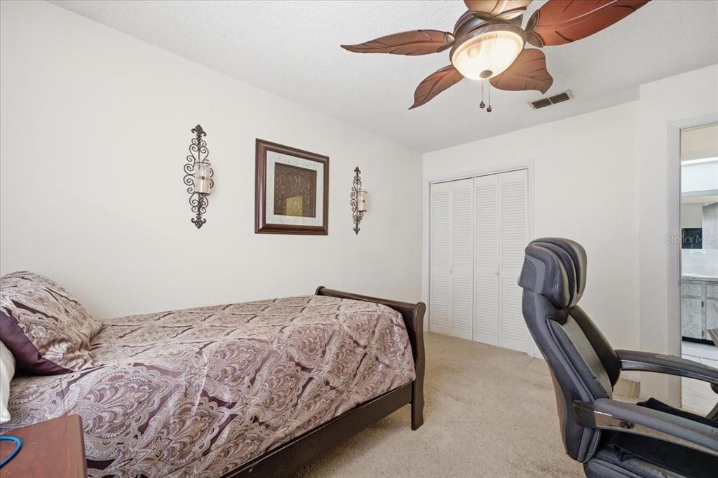 12439 Hanley Drive Spring Hill, FL 34608 - Photo 29 of 36 a bedroom with a bed and a chandelier