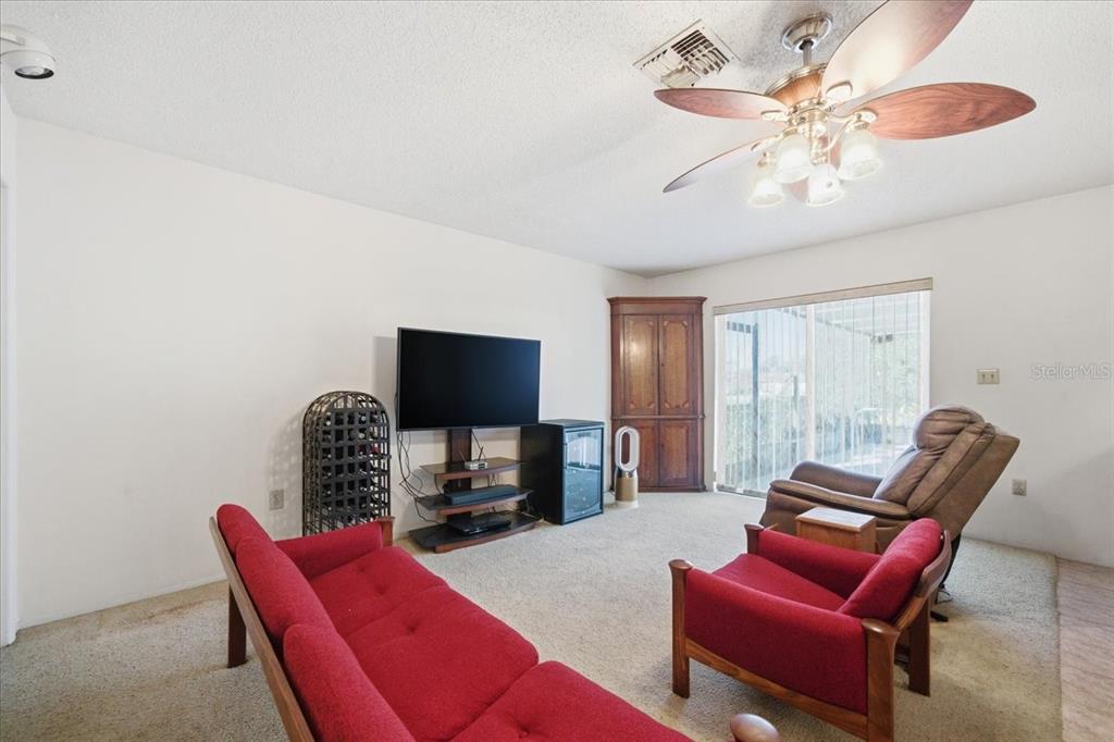 12439 Hanley Drive Spring Hill, FL 34608 - Photo 9 of 36 a living room with furniture a flat screen tv and a window
