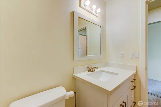 a bathroom with a sink mirror and toilet