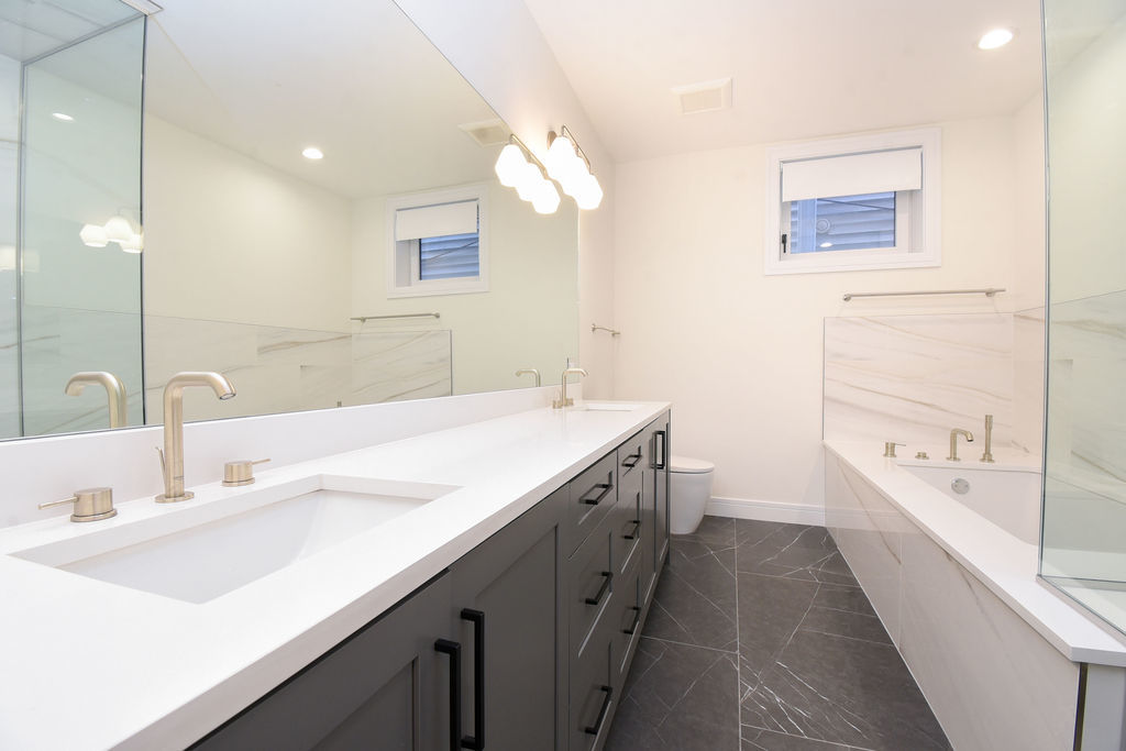 Undisclosed Address Chicago, IL 60613 - Photo 38 of 50 a bathroom with a double vanity sink a mirror and a bathtub