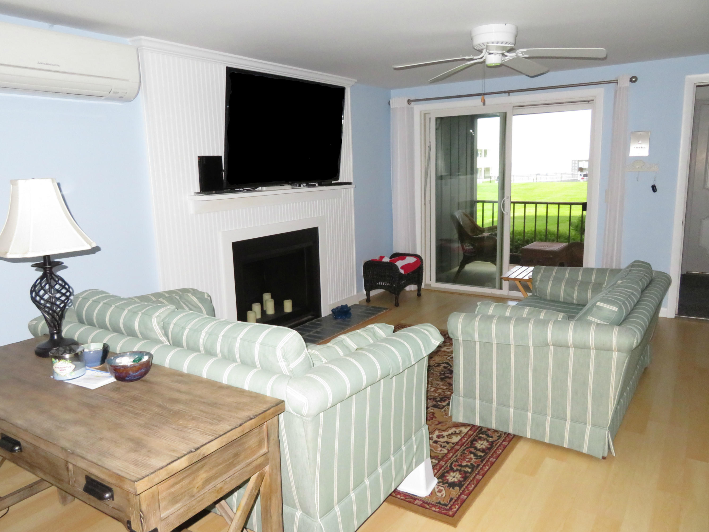 112 Old Wharf Road, Unit W9 Dennis Port, MA 02639 - Photo 2 of 19 a living room with furniture a flat screen tv and a fireplace