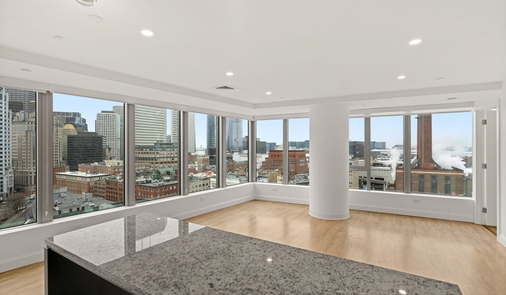 99 Kneeland Street, Unit 1903 Boston, MA 02111 - Photo 1 of 16 a view of an empty room with wooden floor and a window