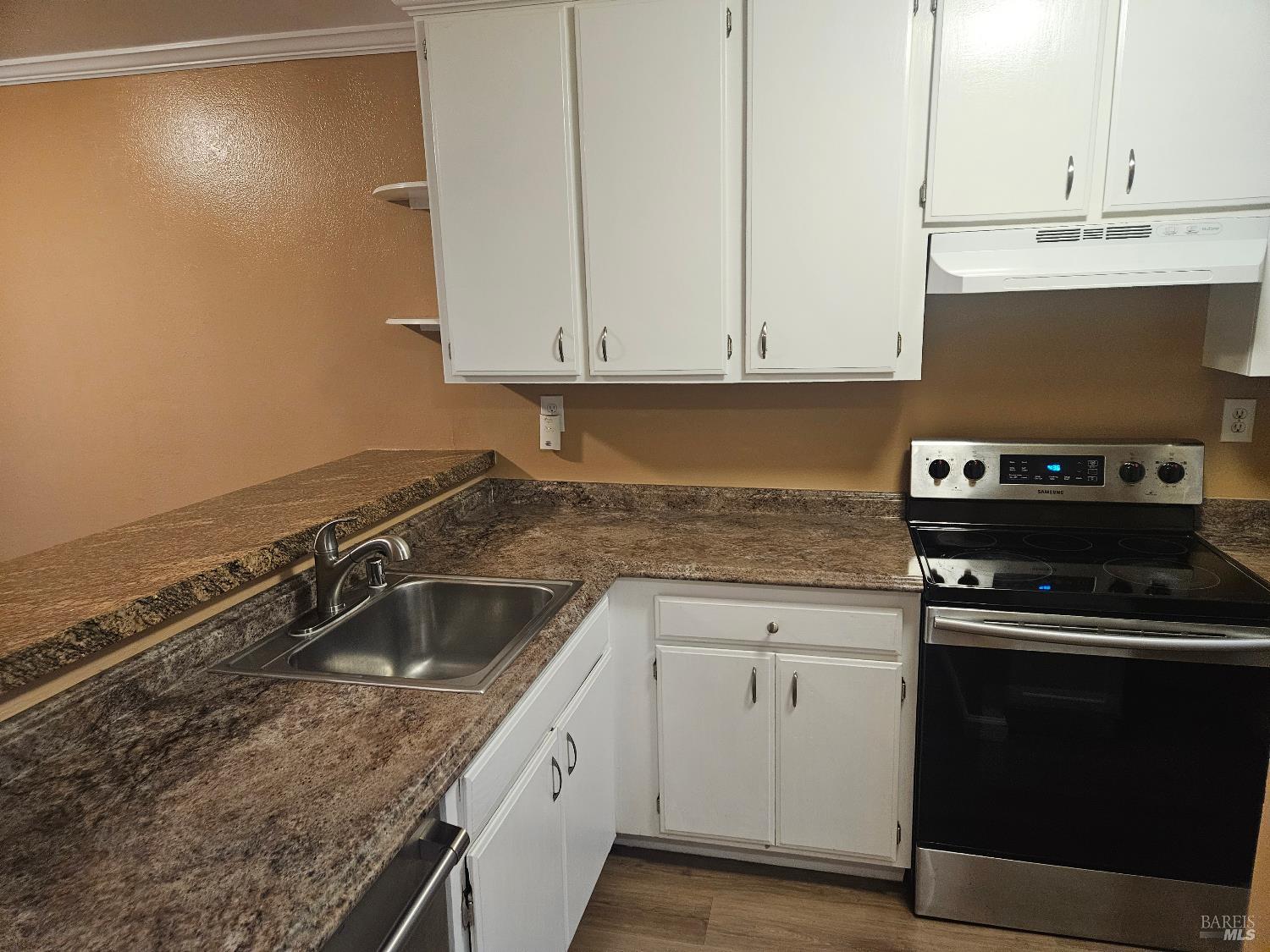a kitchen with granite countertop a sink and cabinets