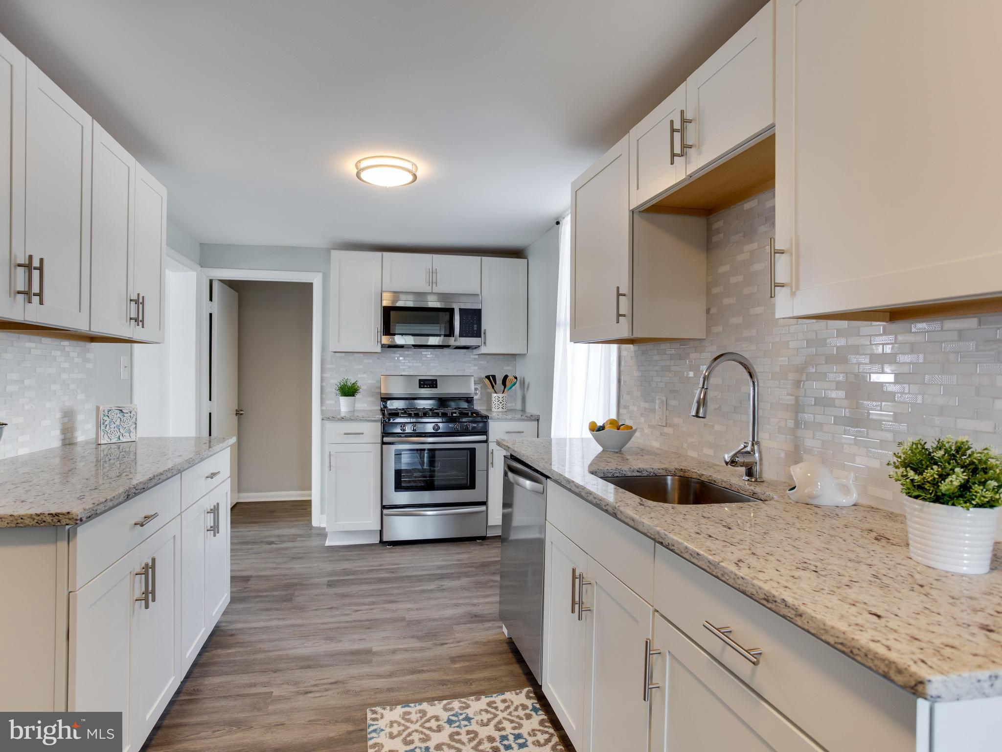 110 West Hilltop Road Baltimore, MD 21225 - Photo 11 of 30 a kitchen with granite countertop a sink and white stainless steel appliances