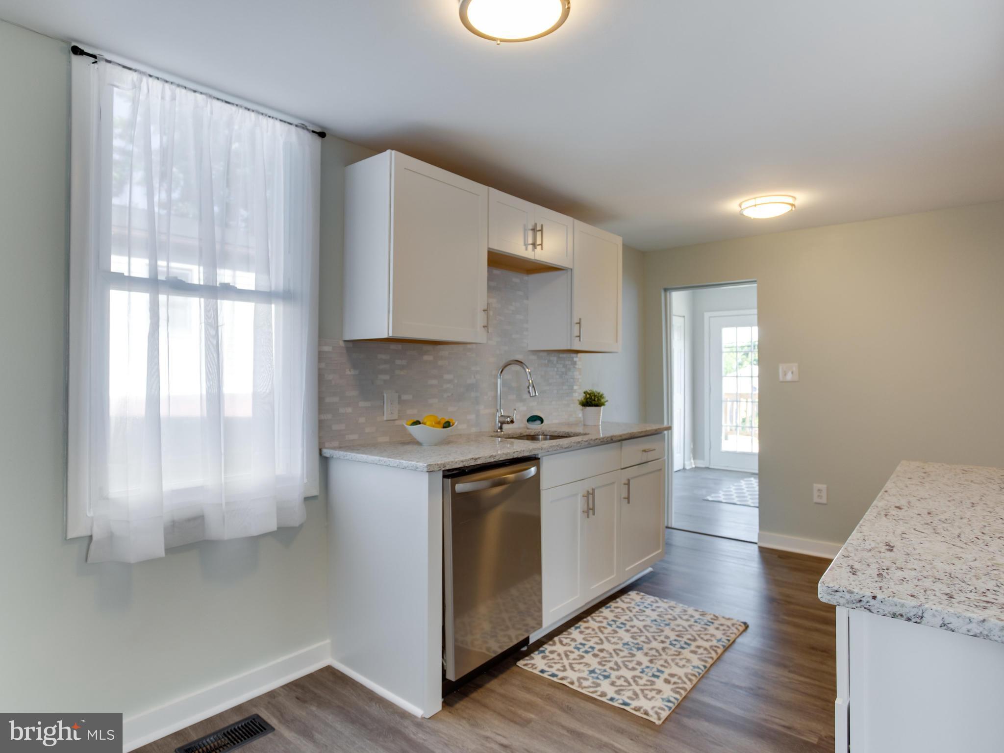 110 West Hilltop Road Baltimore, MD 21225 - Photo 14 of 30 a kitchen with granite countertop white cabinets and white appliances