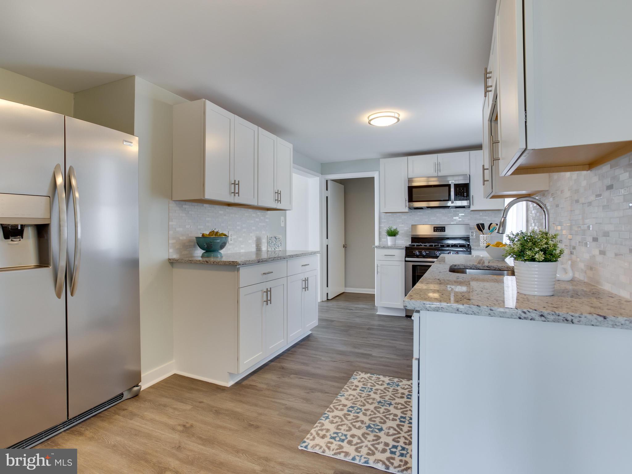 110 West Hilltop Road Baltimore, MD 21225 - Photo 15 of 30 a kitchen with stainless steel appliances granite countertop a refrigerator a stove a sink a microwave a counter space and cabinets