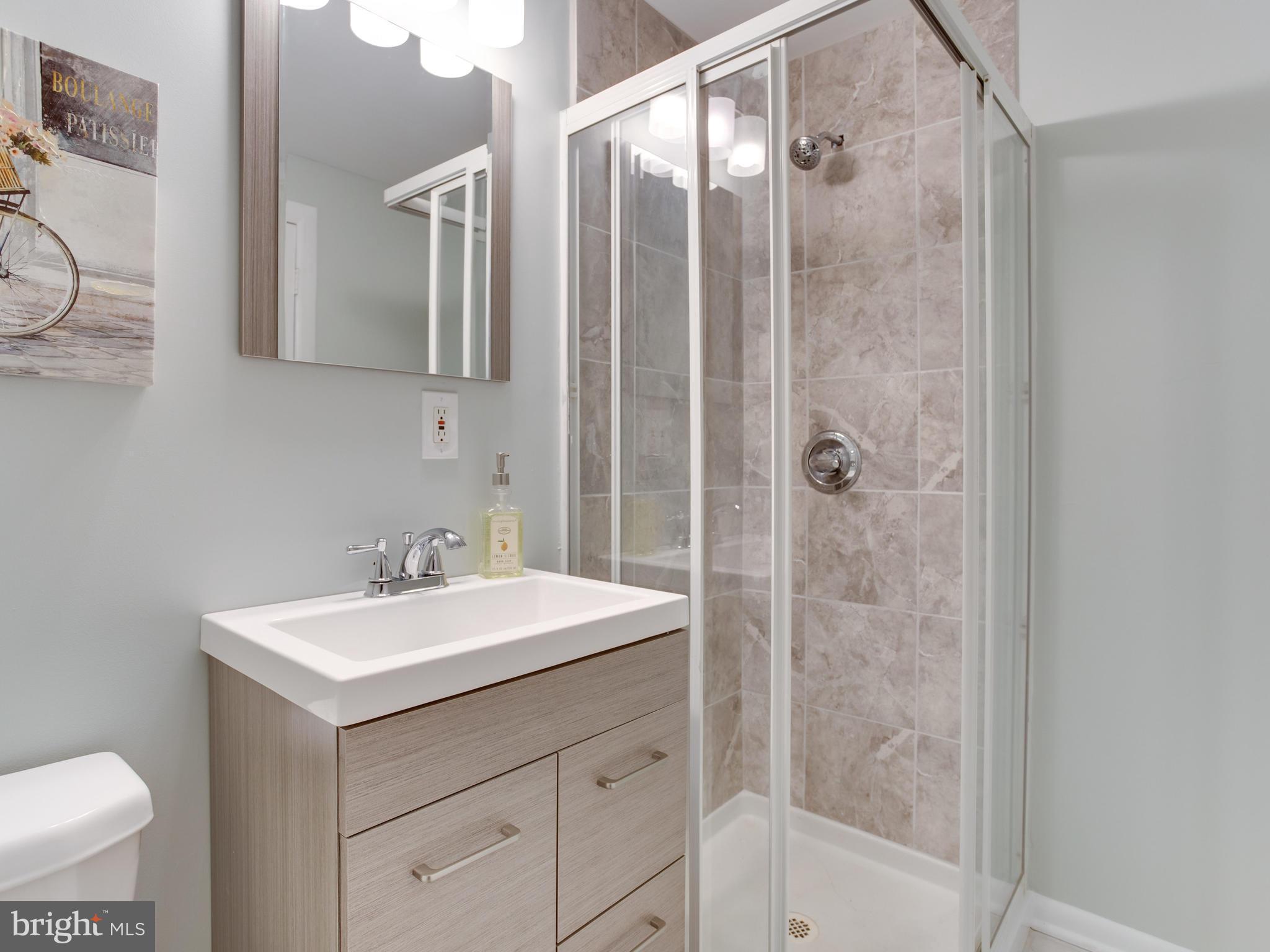110 West Hilltop Road Baltimore, MD 21225 - Photo 19 of 30 a bathroom with a sink mirror vanity and toilet