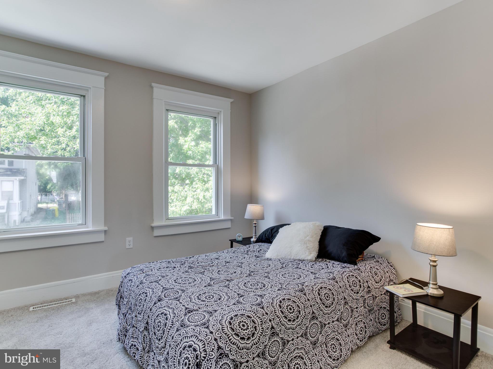 110 West Hilltop Road Baltimore, MD 21225 - Photo 23 of 30 a bedroom with a bed and a lamp next to a window