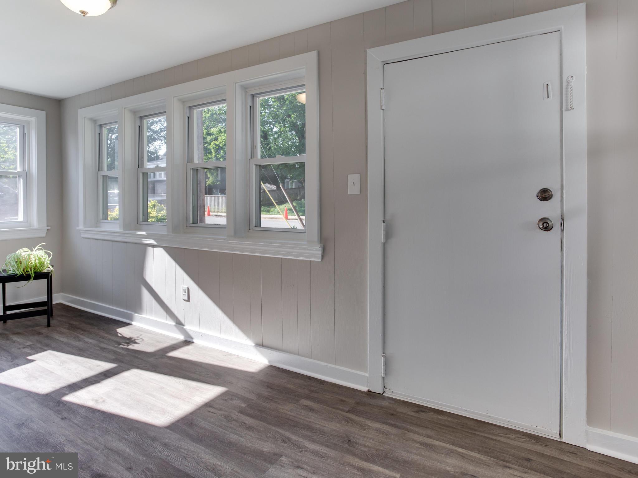 110 West Hilltop Road Baltimore, MD 21225 - Photo 4 of 30 an empty room with wooden floor and windows