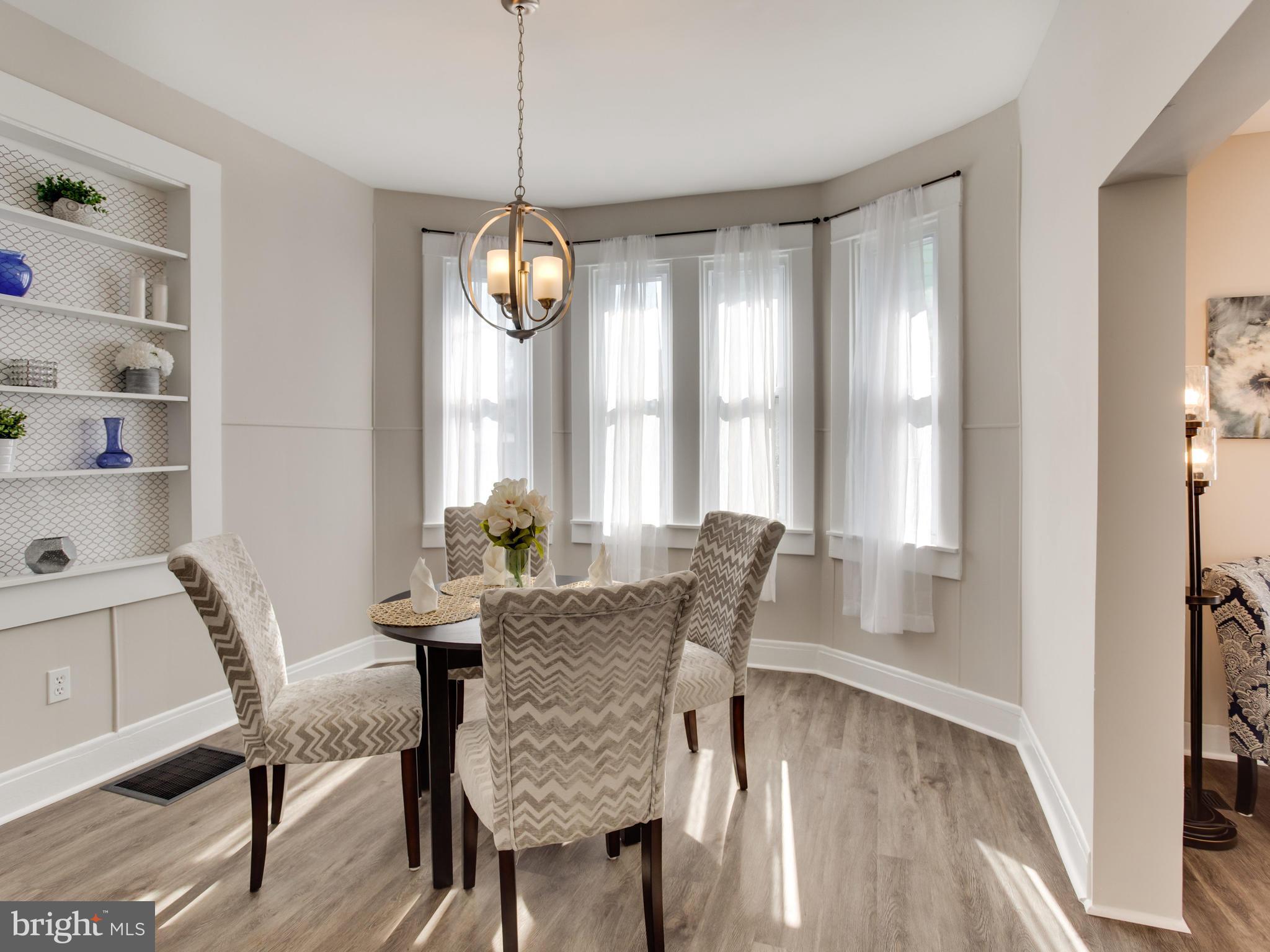 110 West Hilltop Road Baltimore, MD 21225 - Photo 9 of 30 a dining room with furniture a chandelier and wooden floor