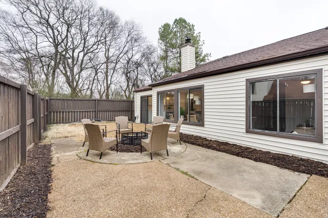 a view of a patio with table and chairs and wooden fence