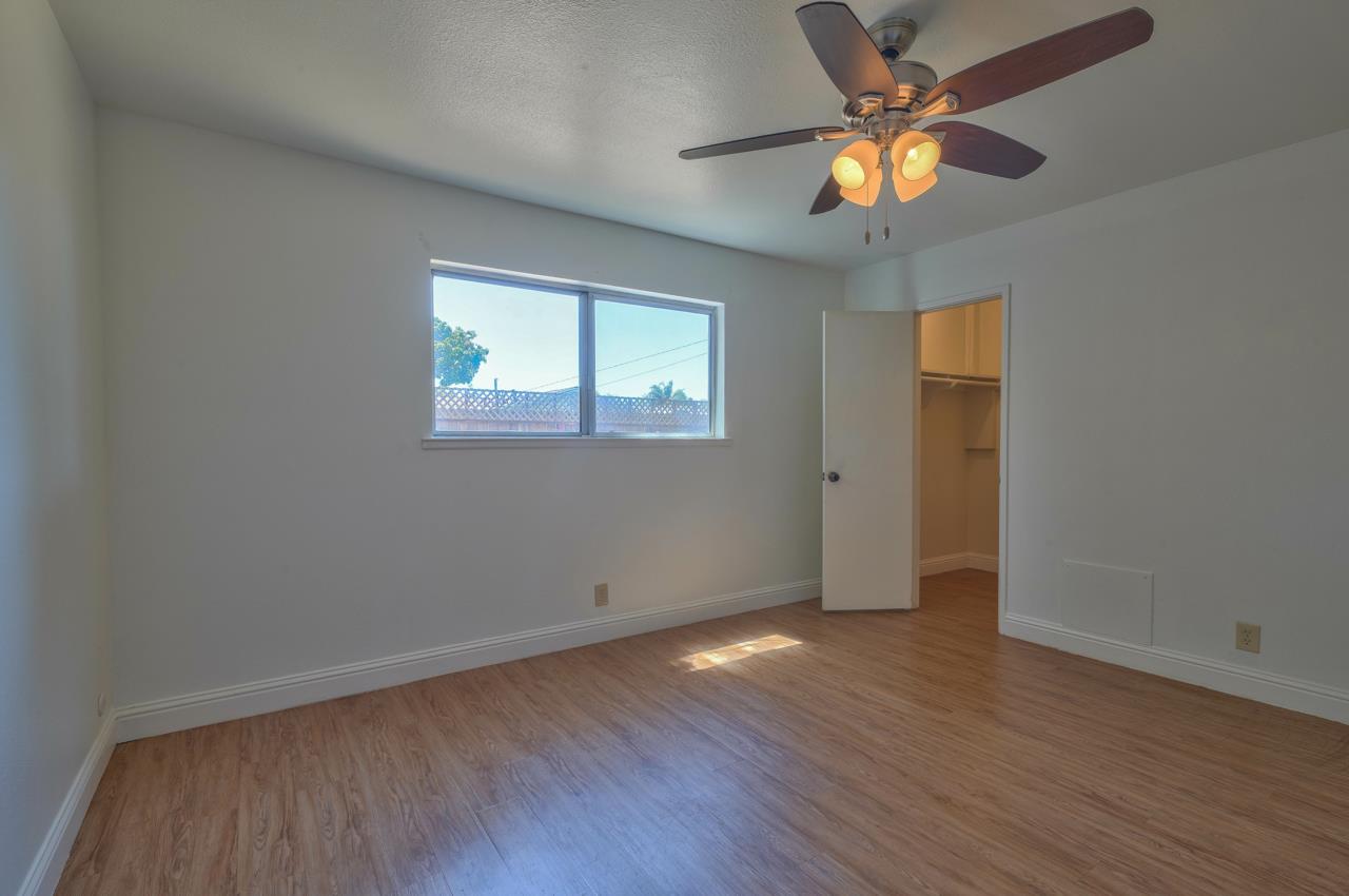 736 Sausal Drive Salinas, CA 93906 - Photo 18 of 24 an empty room with wooden floor chandelier fan and windows