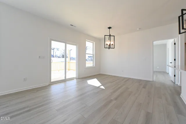 a large white kitchen with wooden floor and stainless steel appliances