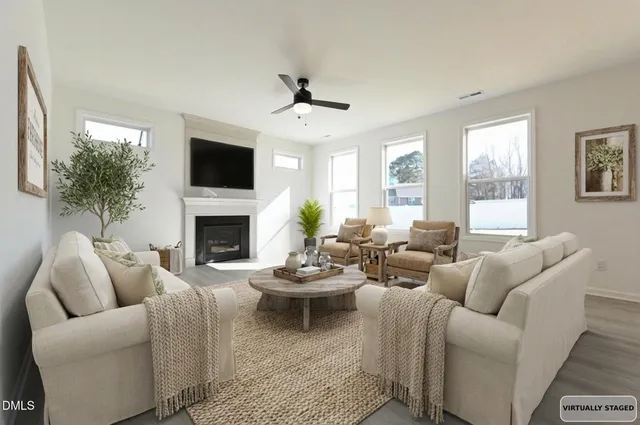 an empty room with wooden floor fireplace and windows