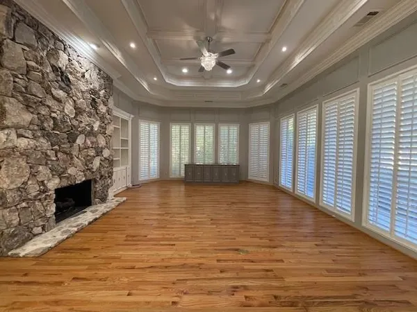 a view of an empty room with a fireplace and a window