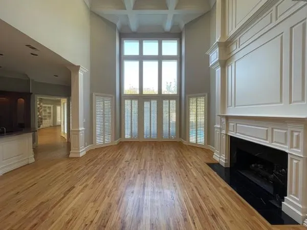 a view of empty room with wooden floor and fireplace
