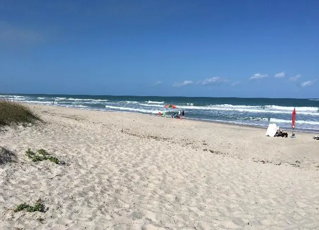 a view of water heater and room with wooden floor