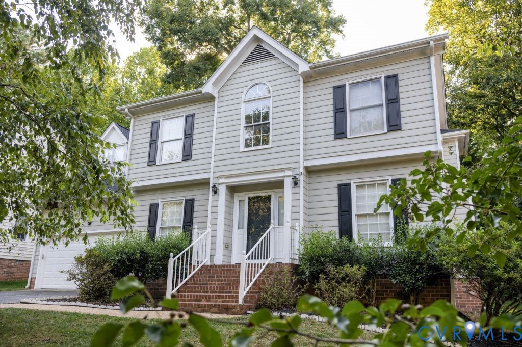 a view of a house with a yard and potted plants