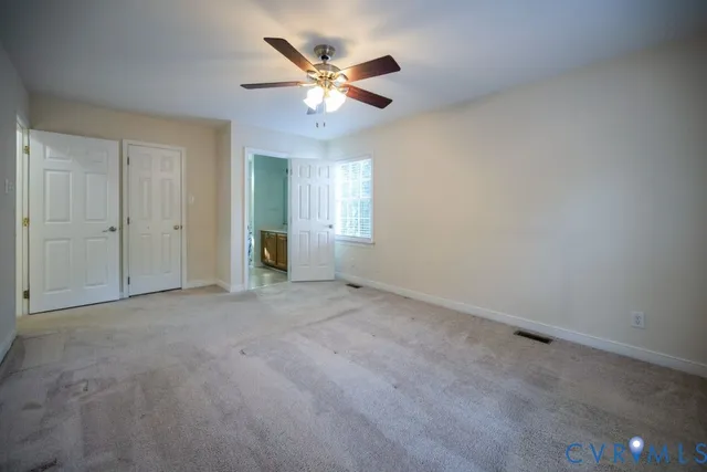 an empty room with closet and windows