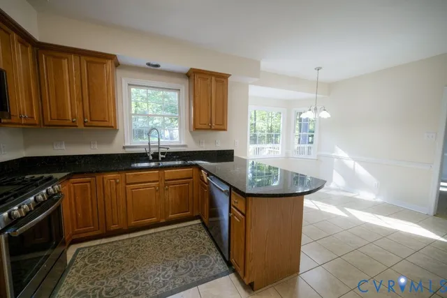 a kitchen with stainless steel appliances granite countertop a sink stove and cabinets
