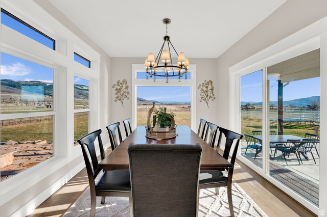 352 East Boulderville Road Oakley, UT 84055 - Photo 16 of 62 Dining space with a mountain view, light wood-type flooring, a chandelier, and plenty of natural light