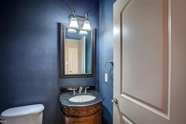 a bathroom with a toilet sink and mirror