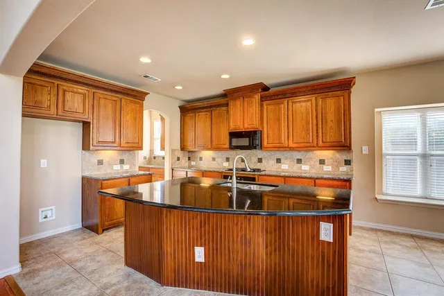 a kitchen with stainless steel appliances granite countertop a stove a sink dishwasher and a refrigerator