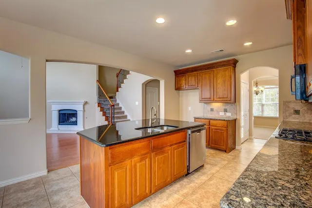a kitchen with stainless steel appliances granite countertop a stove a sink and a refrigerator