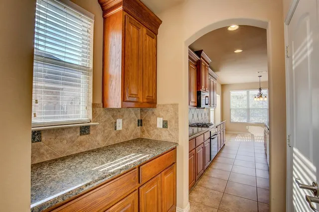 a bathroom with a granite countertop sink and washing machine