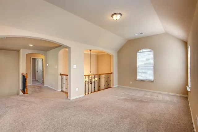 a view of a hallway with an entryway and an empty room