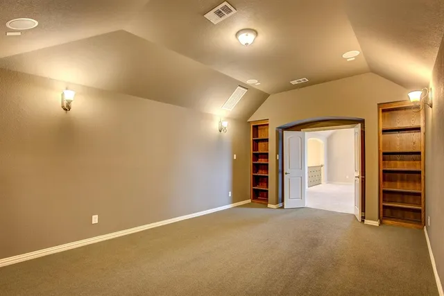 an empty room with a ceiling fan and carpet
