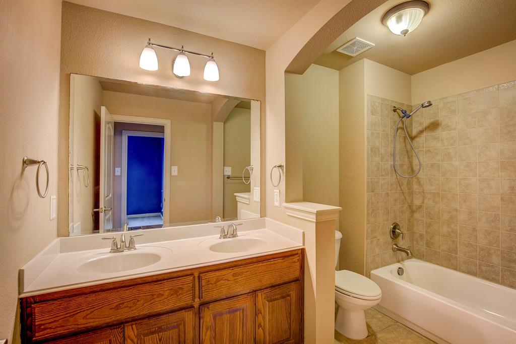9017 Hawley Drive Fort Worth, TX 76244 - Photo 35 of 40 a bathroom with a sink a toilet and a large mirror