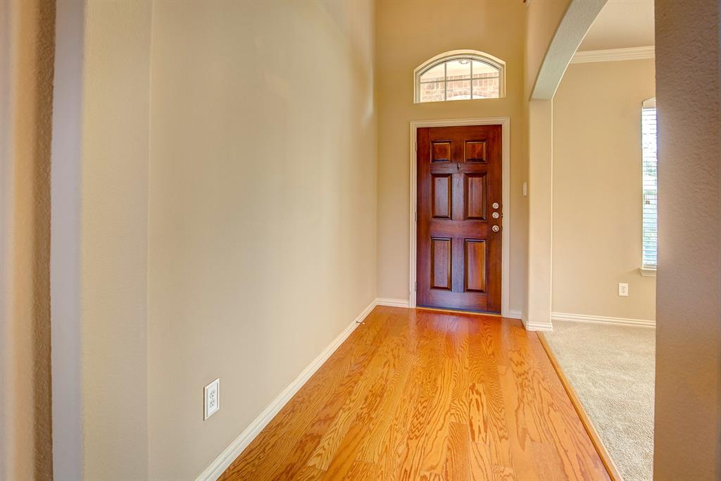 9017 Hawley Drive Fort Worth, TX 76244 - Photo 6 of 40 a view of a hallway with wooden floor and a bathroom