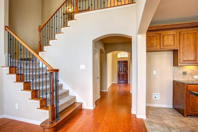 a view of staircase with wooden floor and a chandelier