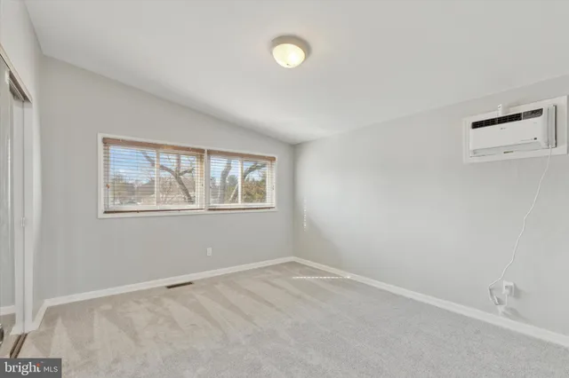 an empty room with windows and closet