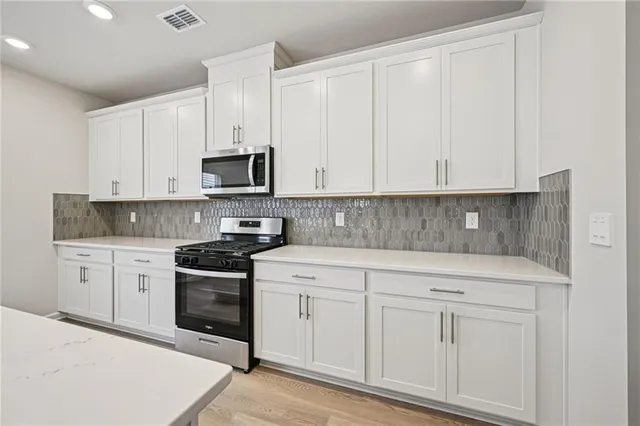 a kitchen with white cabinets stainless steel appliances and sink