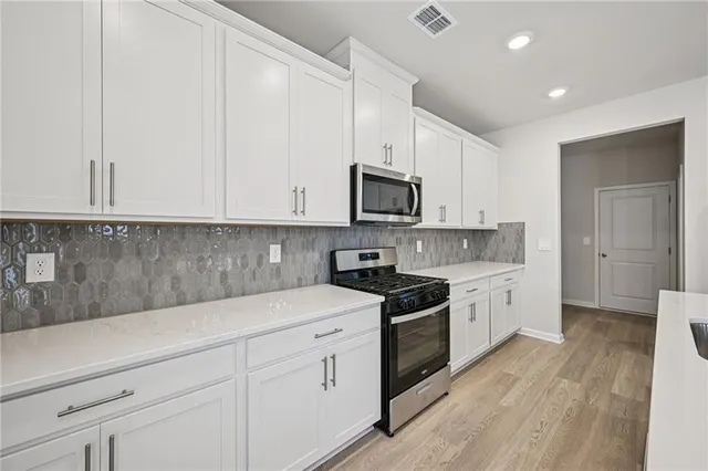 a view of kitchen with sink refrigerator and microwave