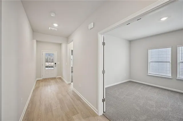a view of hallway with a fireplace and wooden floor