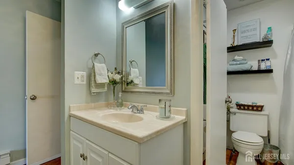 a bathroom with a sink toilet and a mirror
