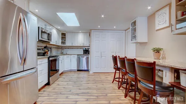 a kitchen with stainless steel appliances granite countertop a refrigerator and a stove top oven