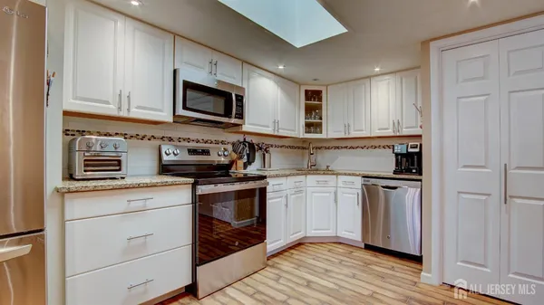 a kitchen with stainless steel appliances granite countertop a stove and a microwave