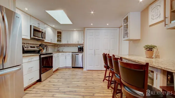 a kitchen with stainless steel appliances kitchen island granite countertop a stove a sink a microwave and a refrigerator