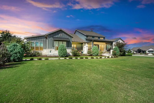 a front view of a house with a garden and trees