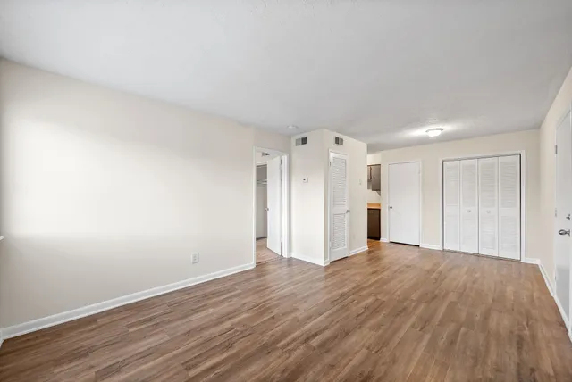a view of an empty room with wooden floor