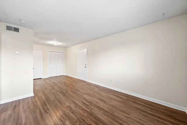 a view of empty room with wooden floor