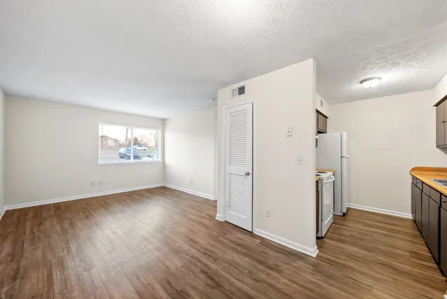 an empty room with wooden floor and a window