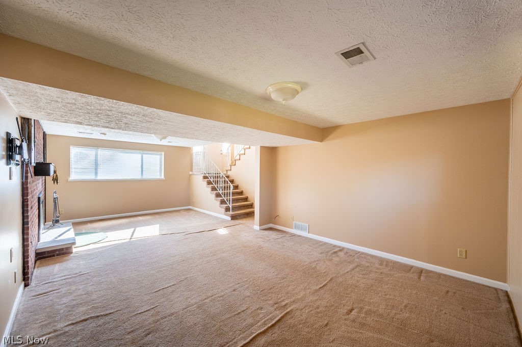 3601 River Road Vienna, WV 26105 - Photo 27 of 40 Below grade area featuring a textured ceiling and light carpet