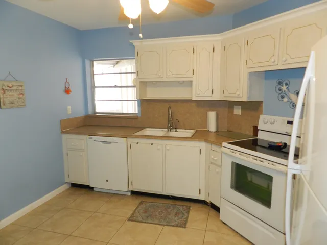 a view of a kitchen with white cabinets